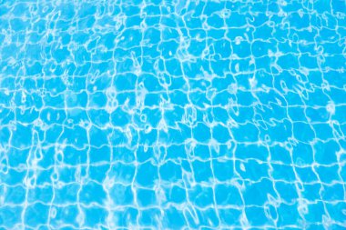 Mavi yüzme havuzunun arka planındaki sudan yansımalar.