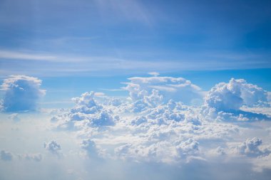 Gökyüzü ve yerden görünen bulutlar, açık renkli arka planlı bir uçaktan görüldü.