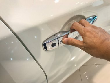 Adamın eli arabanın arka kapısını açıyor.