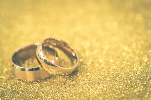 Gelinin ve damadın altın alyansları altın kaplama arka planda