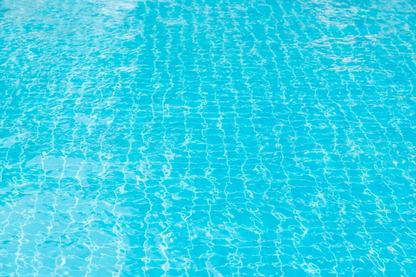Mavi yüzme havuzunun arka planındaki sudan yansımalar.