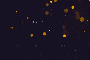Siyah arkaplanda koyu soyut altın bokeh parıltısı