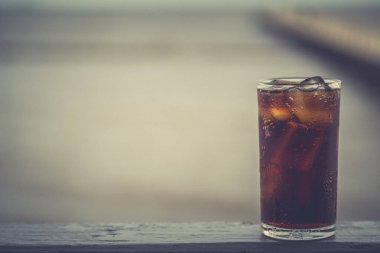 Buzlu kola, arka planda tazelenmek üzere içilmeye hazır.