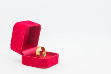 Beyaz arka planda kırmızı kadife kutuda alyans