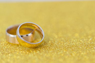 Gelinin ve damadın altın alyansları altın kaplama arka planda