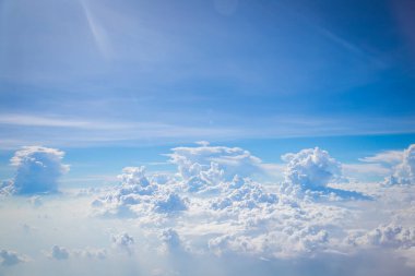 Gökyüzü ve yerden görünen bulutlar, açık renkli arka planlı bir uçaktan görüldü.