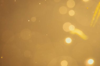 Siyah arkaplanda koyu soyut altın bokeh parıltısı