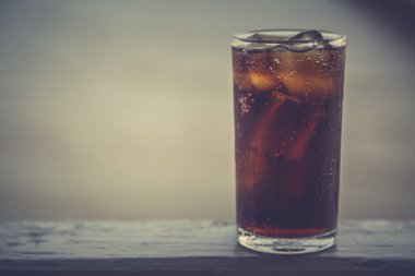 Buzlu kola, arka planda tazelenmek üzere içilmeye hazır.