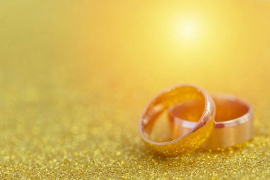 Gelinin ve damadın altın alyansları altın kaplama arka planda