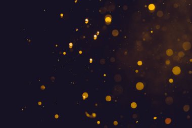 Siyah arkaplanda koyu soyut altın bokeh parıltısı