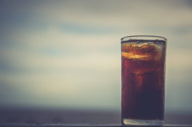 Buzlu kola, arka planda tazelenmek üzere içilmeye hazır.