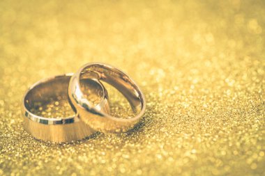 Gelinin ve damadın altın alyansları altın kaplama arka planda