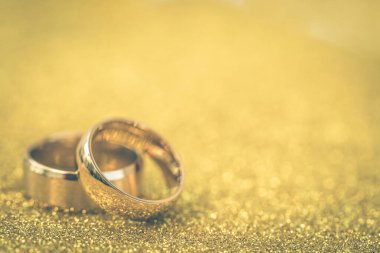 Gelinin ve damadın altın alyansları altın kaplama arka planda