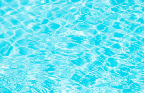 Mavi yüzme havuzunun arka planındaki sudan yansımalar.