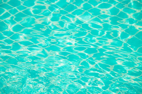 Mavi yüzme havuzunun arka planındaki sudan yansımalar.