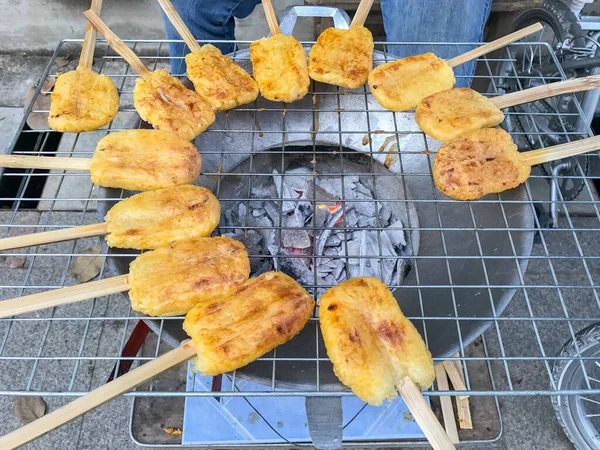 Kömür ocağında ızgara yumurta ile boyanmış glutinous pilavı.