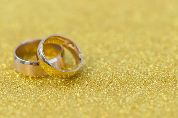 Gouden Trouwringen Van Bruid Bruidegom Gouden Gliter Achtergrond — Stockfoto