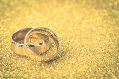 Gelinin ve damadın altın alyansları altın kaplama arka planda