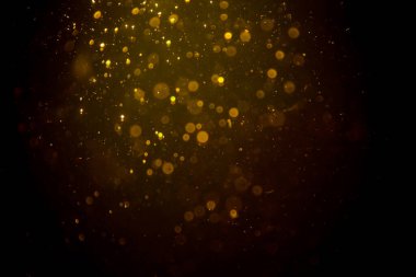 Siyah arkaplanda koyu soyut altın bokeh parıltısı