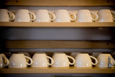 Raflara seramik kahve fincanları yerleştirildi.