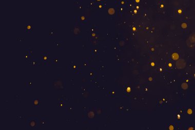 Siyah arkaplanda koyu soyut altın bokeh parıltısı