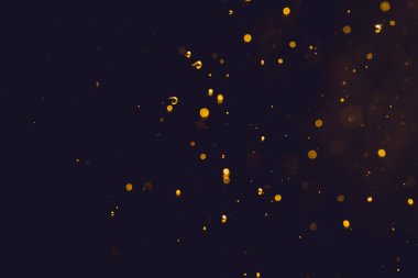Siyah arkaplanda koyu soyut altın bokeh parıltısı