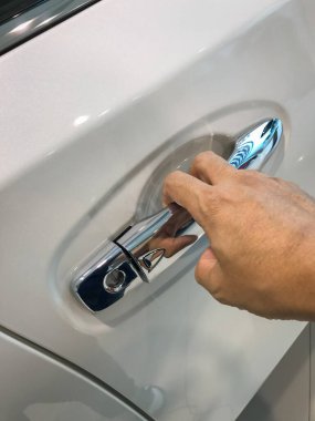 Adamın eli arabanın arka kapısını açıyor.