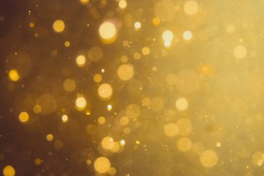 Siyah arkaplanda koyu soyut altın bokeh parıltısı