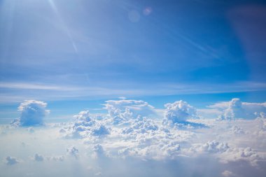 Gökyüzü ve yerden görünen bulutlar, açık renkli arka planlı bir uçaktan görüldü.