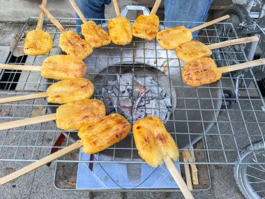 Kömür ocağında ızgara yumurta ile boyanmış glutinous pilavı.