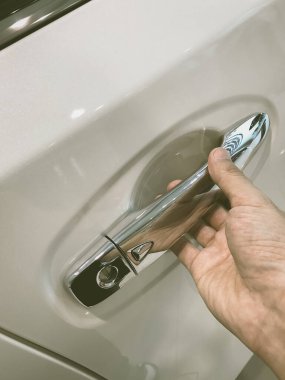 Adamın eli arabanın arka kapısını açıyor.