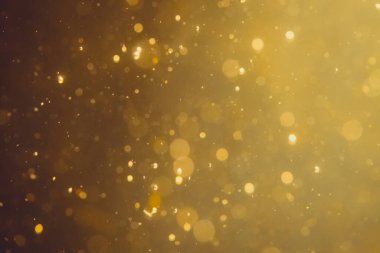 Siyah arkaplanda koyu soyut altın bokeh parıltısı