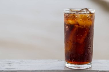 Buzlu kola, arka planda tazelenmek üzere içilmeye hazır.