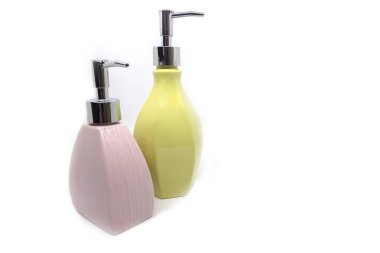 Beyaz arka planda çok renkli duş jeli şişeleri.