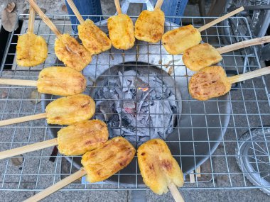 Kömür ocağında ızgara yumurta ile boyanmış glutinous pilavı.