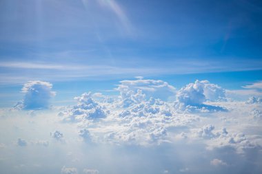 Gökyüzü ve yerden görünen bulutlar, açık renkli arka planlı bir uçaktan görüldü.