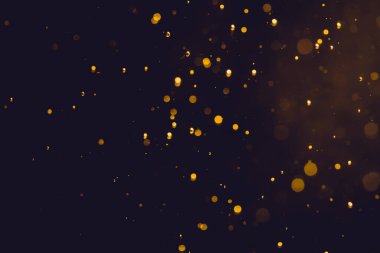 Siyah arkaplanda koyu soyut altın bokeh parıltısı