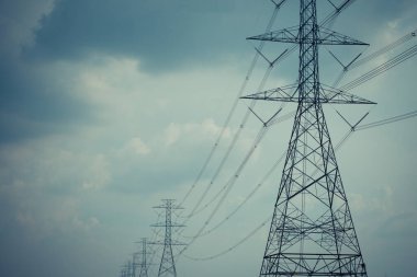 Yüksek voltaj direği kablosu ve bulutlu mavi gökyüzü.