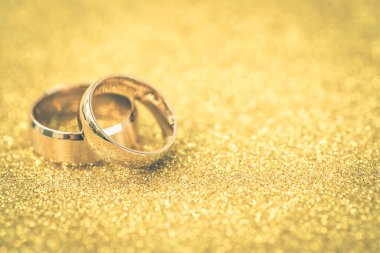 Gelinin ve damadın altın alyansları altın kaplama arka planda