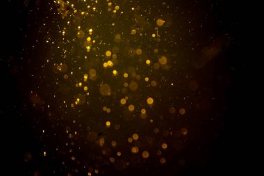 Siyah arkaplanda koyu soyut altın bokeh parıltısı