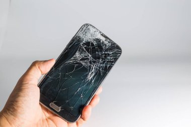 Kırık ekran ile cep telefonu tutan el