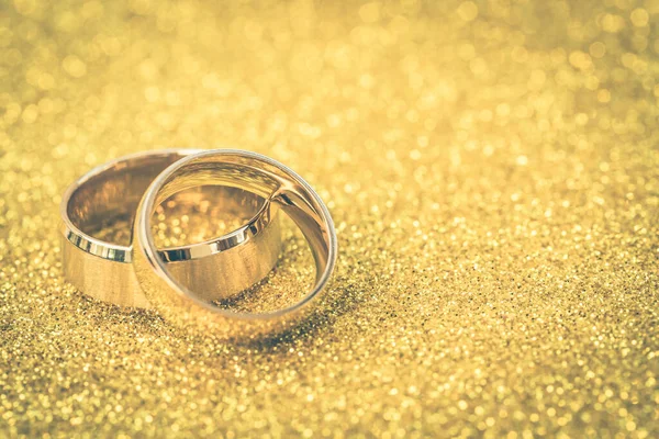 Gelinin ve damadın altın alyansları altın kaplama arka planda