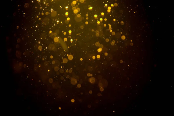 Siyah arkaplanda koyu soyut altın bokeh parıltısı