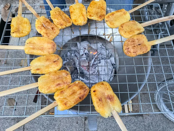 Kömür ocağında ızgara yumurta ile boyanmış glutinous pilavı.