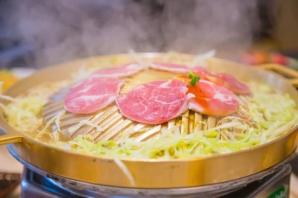 Domuz slaytları pirinçten tavada ızgara yiyecek ve lahana sebzesi.