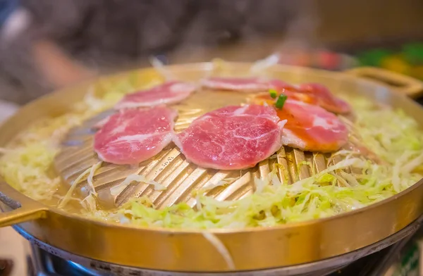 猪肉在黄铜锅里放上卷心菜 把烤好的食物放进去 — 图库照片