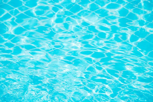 Mavi yüzme havuzunun arka planındaki sudan yansımalar.