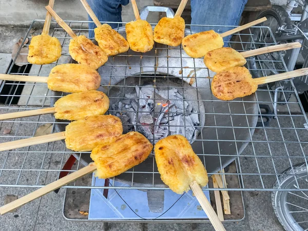 Kömür ocağında ızgara yumurta ile boyanmış glutinous pilavı.