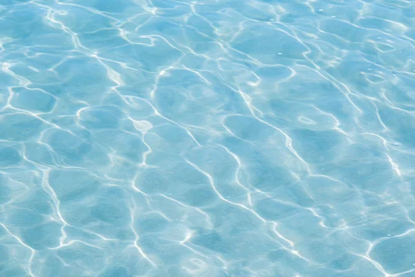 Güneşi yansıtan mavi havuz suyu