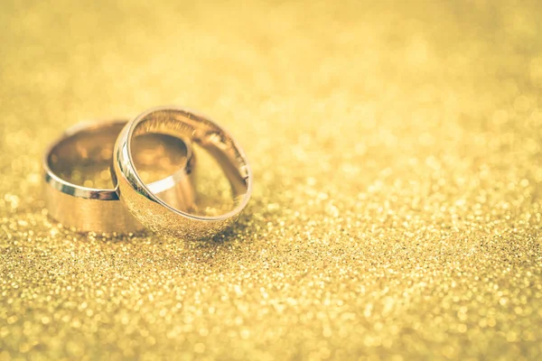 Gelinin ve damadın altın alyansları altın kaplama arka planda